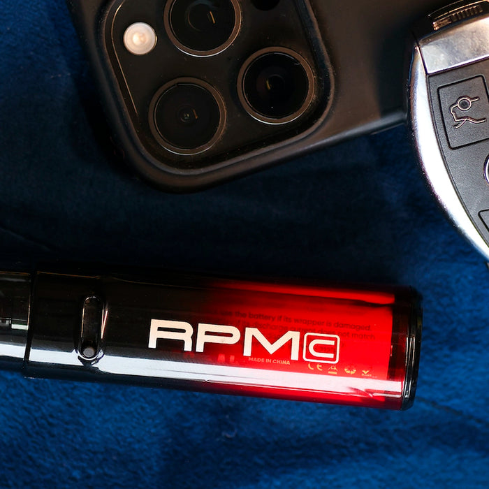 RPM C Vape sitting on blue suede seat with car keys next to it