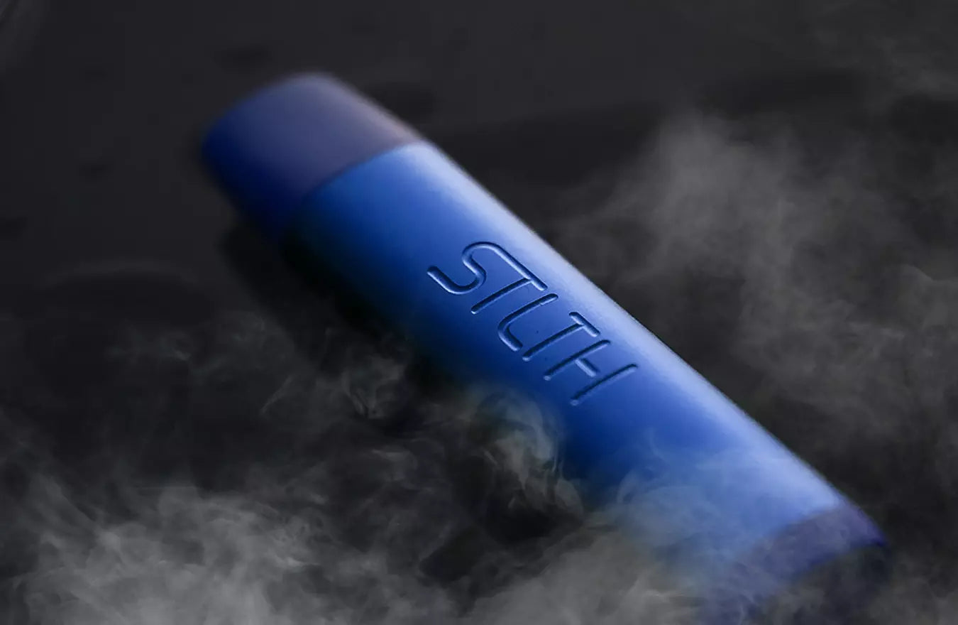 STLTH blue vape with smoke rising over black background