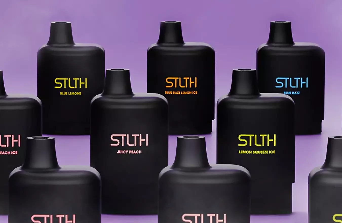 Variety of STLTH vapes next to each other with purple background