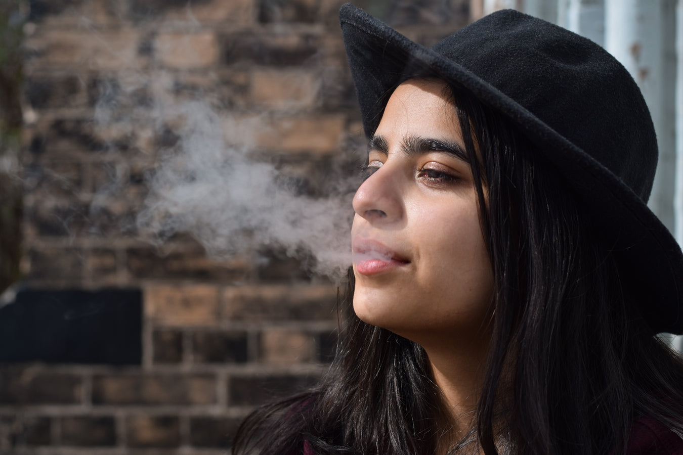 Woman exhaling vape cloud while on trip