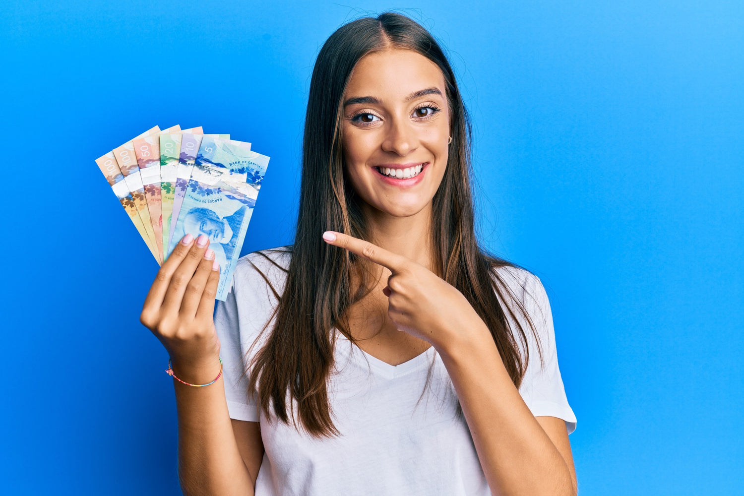 Smiling woman holding Canadian dollars to symbolize savings from vaping vs. smoking