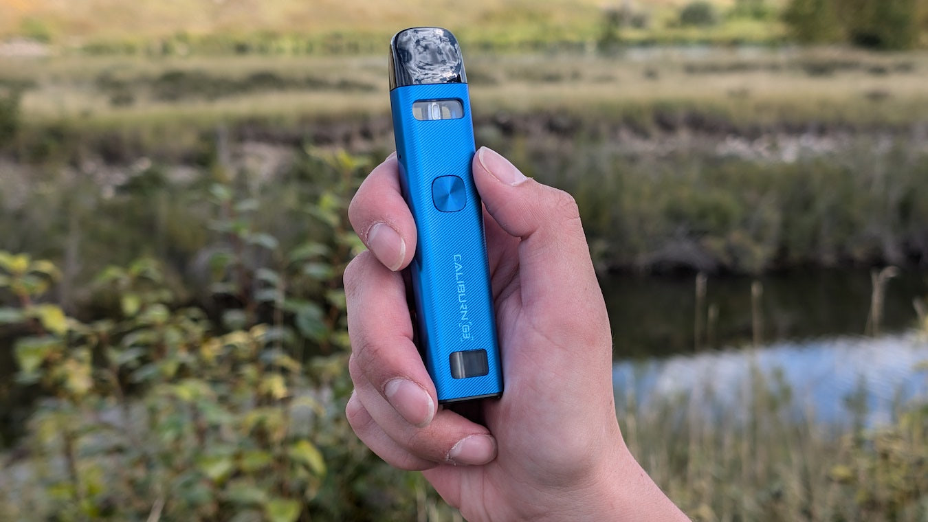 Person holding a cobalt blue UWell Caliburn G3 vape device