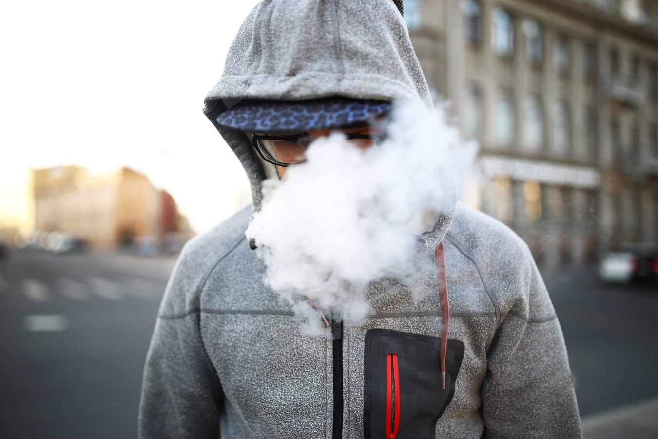 Man blowing cloud after inhaling from vape cart