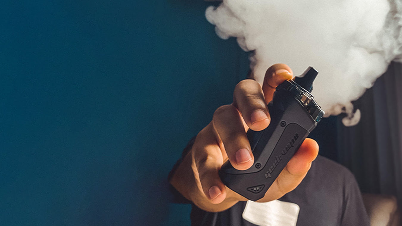 man holding vape and blowing big cloud