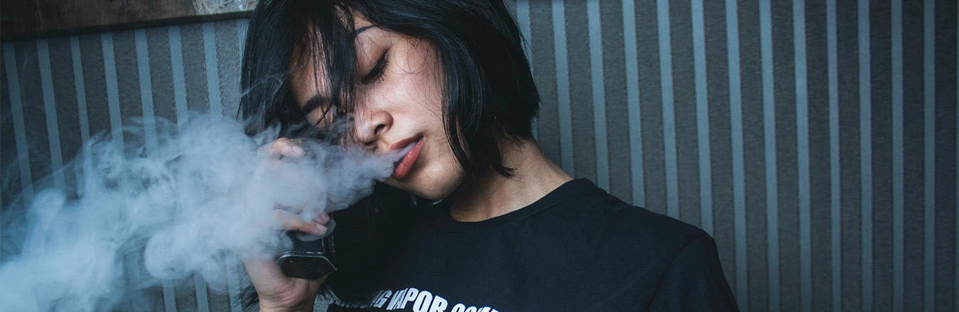 woman blowing vape smoke
