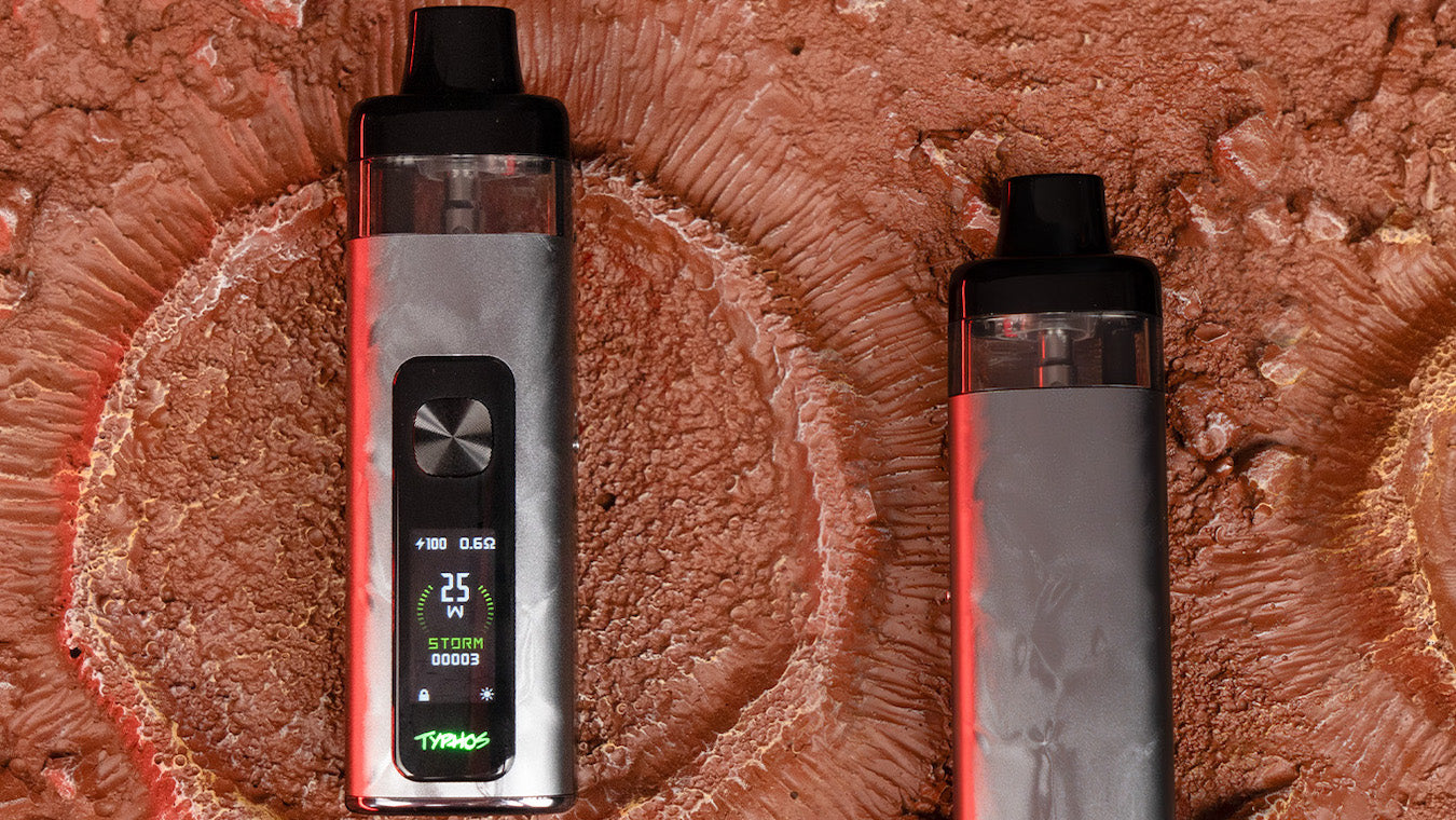 Two UWell Typhos vape devices in Starlight Silver lying on a rocky background showing LED screen with 100% charge